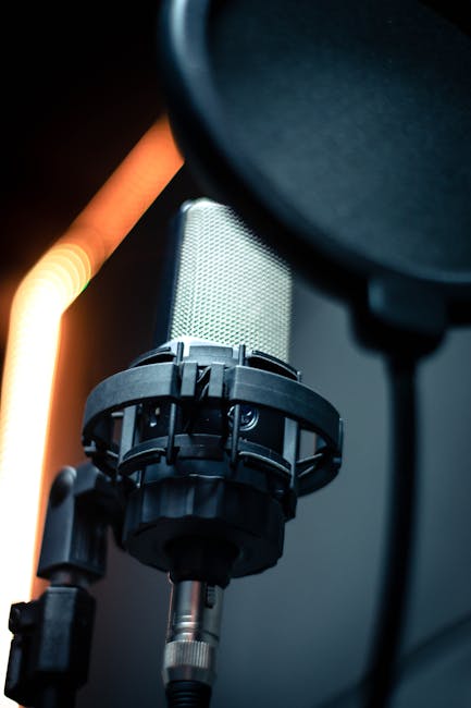 A close-up of a professional condenser microphone with a pop filter, ideal for audio recording.